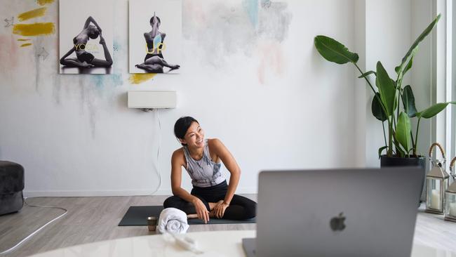 In this picture taken on March 30, 2020, YogaUP founder Chaukei Ngai smiles after concluding a live streamed yoga class via the Zoom online video conferencing platform, at her studio in Discovery Bay, on the outlying Lantau Island in Hong Kong. - More than 3.4 billion people have been called on or forced by authorities to stay at home, around 44 percent of the world population, according to a count based on an AFP database. Many are wondering how they can stay healthy during the weeks -- and possibly months -- of self-isolation that lie ahead. Hong Kongers, who live in some of the world's smallest apartments, say it can be done. (Photo by Anthony WALLACE / AFP) / TO GO WITH HongKong-health-virus-fitness,FOCUS by Jerome TAYLOR