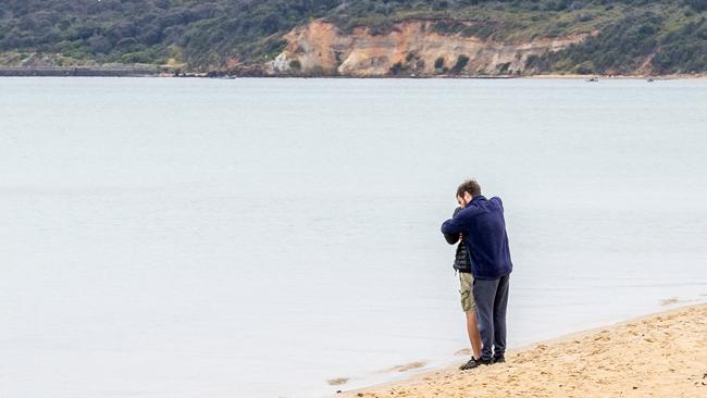 People await news near the Mount Martha Life Saving Club, of those aboard the planes that crashed over Port Phillip Bay on Sunday afternoon. Picture: Jake Nowakowski