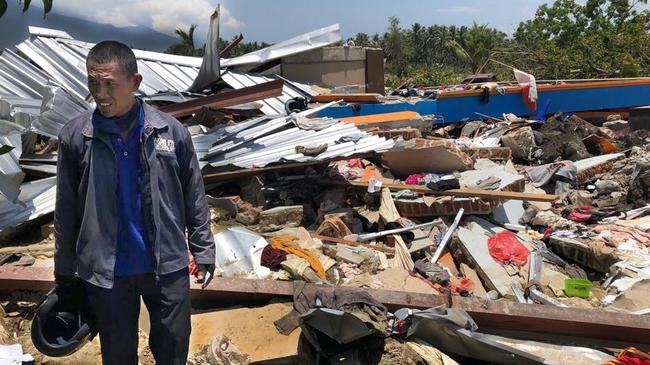 Salvation Army Major Santoso searches mud and rubble for his daughter, Priska, 15, who is among the many children on the camp still missing. Picture: Amanda Hodge