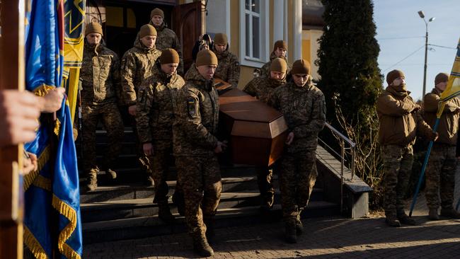 Ukrainian soldiers carry the coffin of a late Ukrainian serviceman during a funeral ceremony in Kyiv on January 2. Picture: Tetiana Dzhafarova/AFP