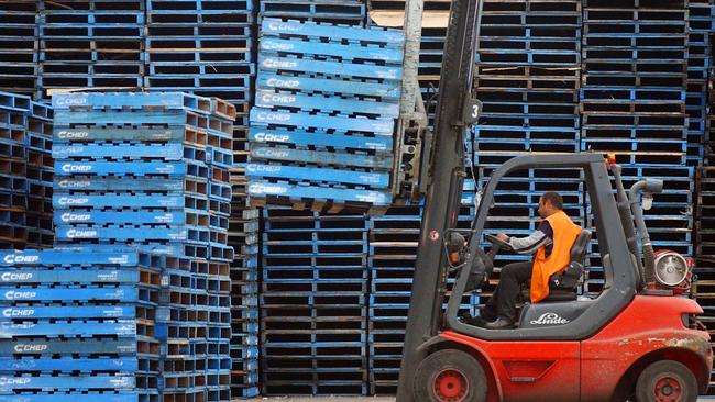 A forklift operator stacks empty wooden pallets at a CHEP pallet depot in Sydney owned by Brambles Industries.