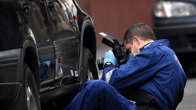 A forensics officer photographs a car in nearby Anthony Street. Picture: Nicole Garmston