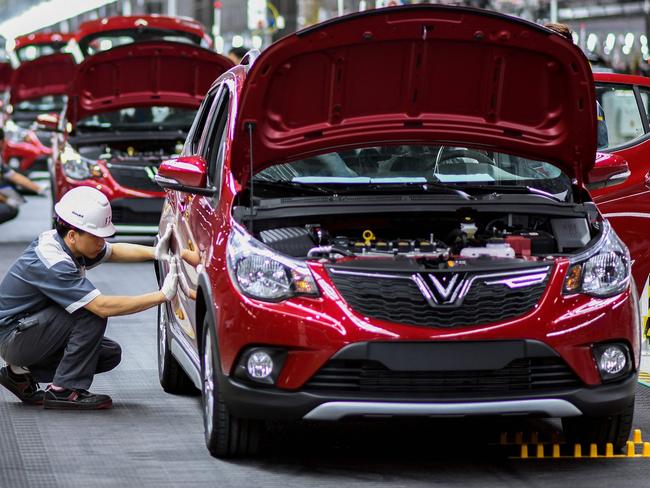 (FILES) In this file photo taken on June 14, 2019, workers operate the car assembly line at the automobile plant of VinFast, Vietnam's first homegrown car manufacturer, in Haiphong. - Vietnam's first homegrown car manufacturer Vinfast said on July 12, 2021 it will launch two new electric vehicle models early next year in north America and Europe, as it pushes to enter the lucrative but crowded market. (Photo by Manan VATSYAYANA / AFP)