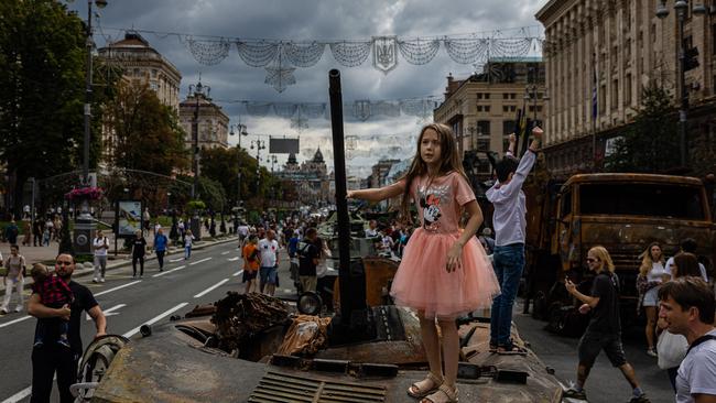 A girl stands on top of destroyed Russian military equipment at Khreshchatyk street in Kyiv. Picture: AFP.