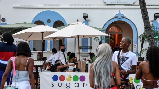 A waiter wears face mask as he works at a restaurant on Ocean Drive in Miami Beach. Picture; AFP.