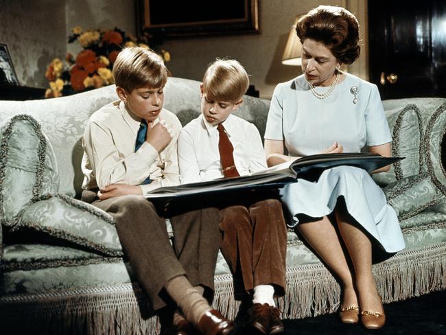 Queen Elizabeth II, with Andrew (L) and Edward, read a book at Buckingham Palace during the recording of Queen's Christmas message. Christmas tradition at Sandringham limits TV and board games. Picture: AFP