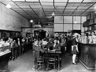 This photograph of the Busy Bee Cafe in Kingaroy was taken on this day (January 2) in 1929. Owner George Trifilis is standing behind the counter. Picture: State Library of Queensland