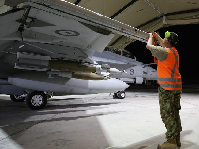 Safety first ... A technician places safety tags on a RAAF F/A-18F Super Hornet aircraft in the Middle East after it completed its first combat mission over Iraq. Picture: Supplied