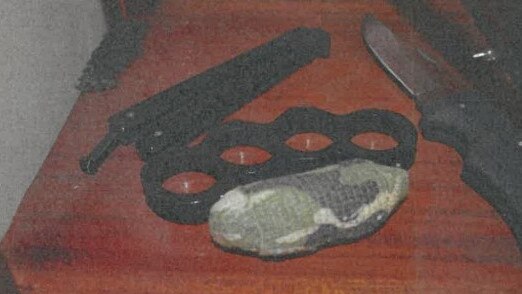 Banned weapons including knuckle dusters and a doubled edged bladed knife were found in a glass display cabinet at Christopher Tatti’s Frankston house. Picture: Victoria Police