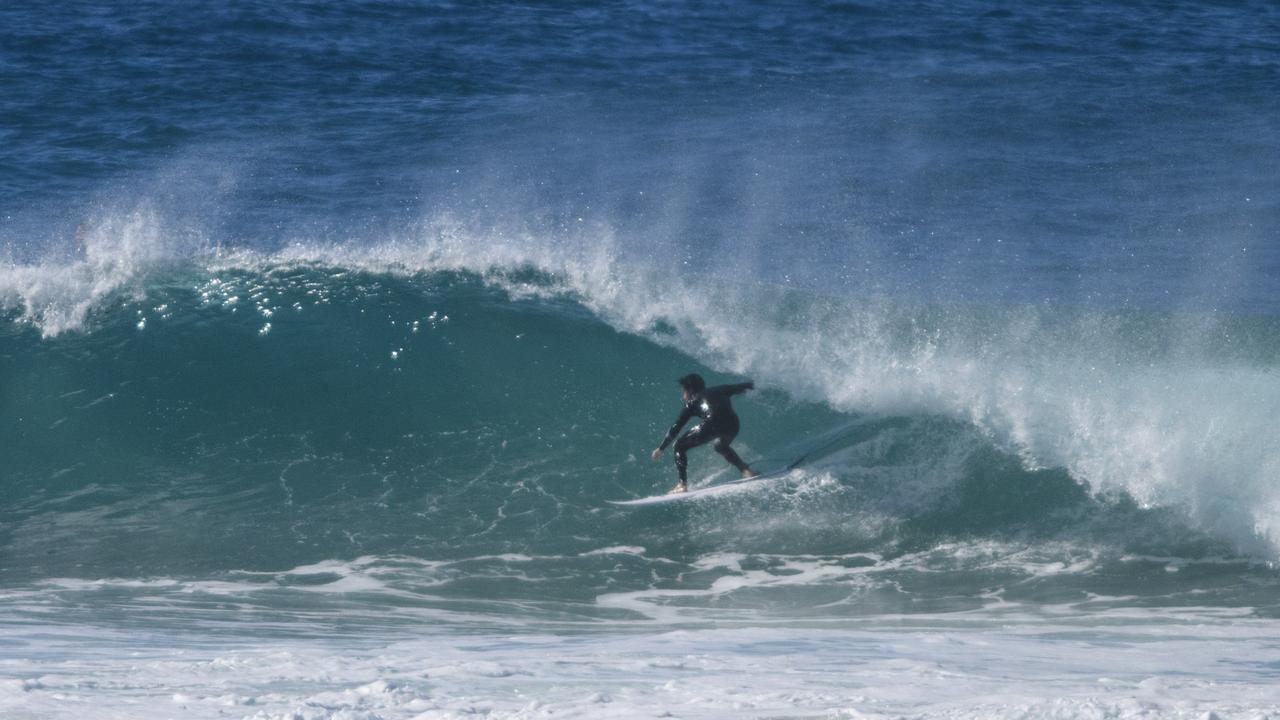 A surfer ducks into a barrel surfing off Green Point at Angourie.