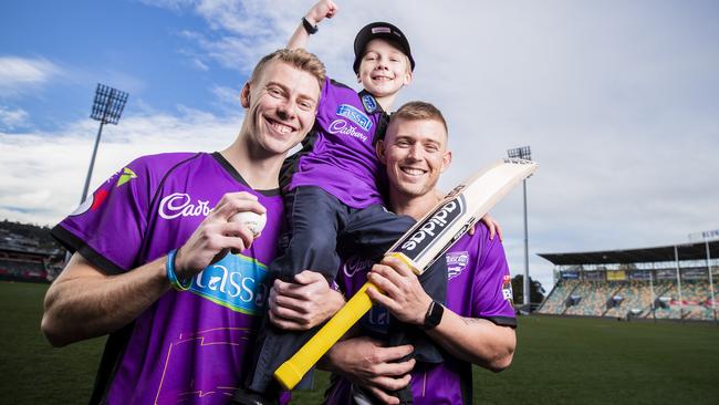 Hurricanes fan Oliver Meers, 7, with Hurricanes players Riley Meredith, left, and Ben McDermott. Picture: RICHARD JUPE