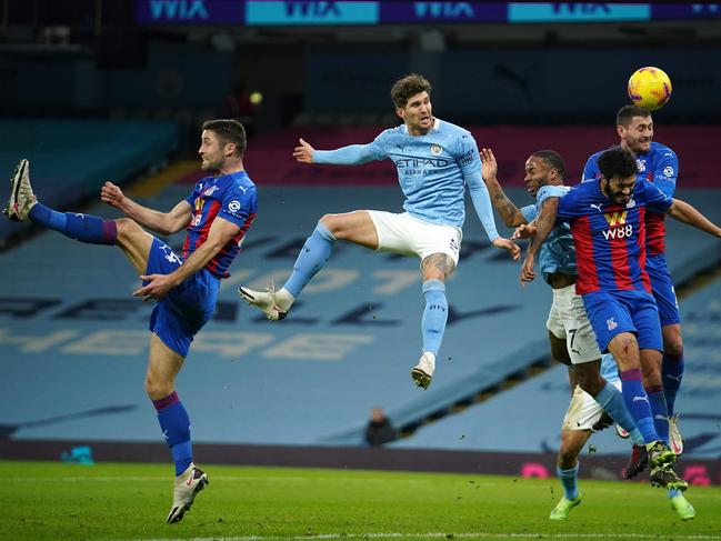 Manchester City's English defender John Stones (C) jumps to head the ball to score the opening goal during the English Premier League football match between Manchester City and Crystal Palace at the Etihad Stadium in Manchester, north west England, on January 17, 2021. (Photo by Dave Thompson / POOL / AFP) / RESTRICTED TO EDITORIAL USE. No use with unauthorized audio, video, data, fixture lists, club/league logos or 'live' services. Online in-match use limited to 120 images. An additional 40 images may be used in extra time. No video emulation. Social media in-match use limited to 120 images. An additional 40 images may be used in extra time. No use in betting publications, games or single club/league/player publications. /