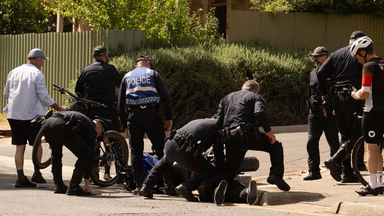 Police hold down a motorcyclist who collided with a cyclist at the Santos Tour Down Under in Tea Tree Gully. Picture: Morgan Sette