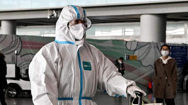 A passenger, wearing a personal protective equipment, walks at the arrival area at the Capital International Airport in Beijing on January 8, 2023. China lifted quarantine requirements for inbound travellers on January 8, ending almost three years of self-imposed isolation even as the country battles a surge in Covid cases. (Photo by Noel CELIS / AFP)