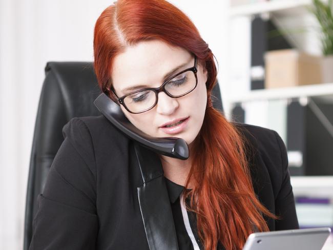 Young businesswoman calling and writing in personal organizer