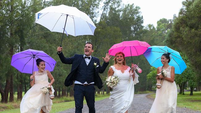 Rain didn’t stop Leni and George Keramidas, pictured with flowergirls Catherine and Eva. Picture: Ian Currie