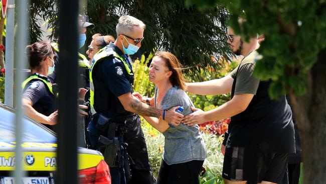 A distraught woman is comforted by police at the scene in Umbria Rd, Mernda. Picture: Mark Stewart