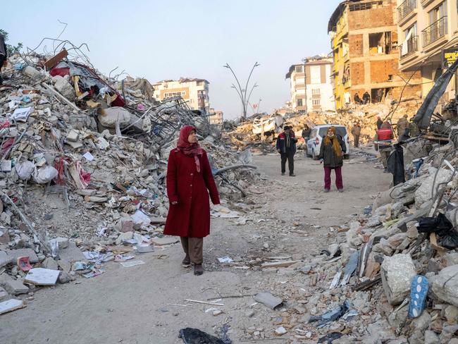 A woman walks by rubble during rescue operations in Hatay. Picture: AFP