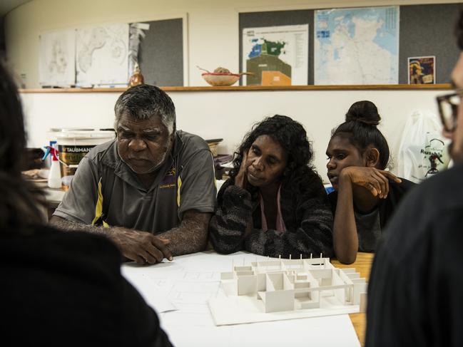 Norm Frank Jupururrla, his wife Serena Morton Nabanunga and daughter look at a cardboard model of a preliminary house designed by Steve Mintern and Simon Robinson (pictured in foreground) from Office, a not-for-profit multidisciplinary design and research practice based in Melbourne, for the Wilya Junta (Standing Strong) Housing Collaboration, inside the Nyinkka Nyunyu Art and Culture Centre in Tennant Creek. Picture: Andrew Quilty