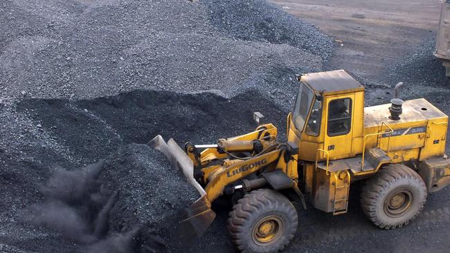 An excavator moving coal onto a truck at a port in Yichang, central China's Hubei province. Picture: AFP