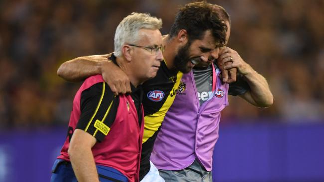 Alex Rance is helped from the field. 