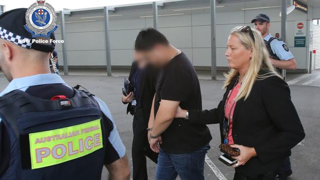 Jian Ke is led away by police at Sydney airport on Saturday. Picture: NSW Police