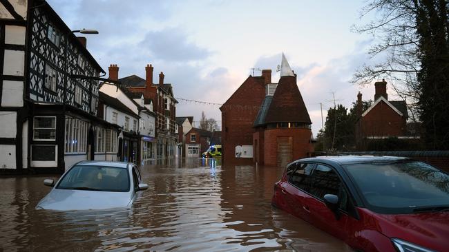 Floodwater surrounds abandoned cars left in a flooded street in Tenbury Wells after the River Teme burst its banks in western England. Picture: Oli Scarff / AFP