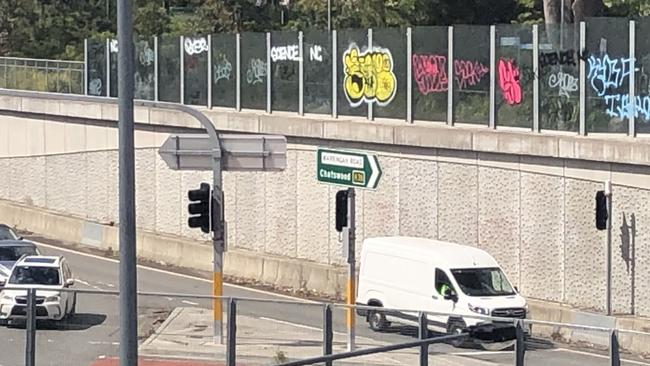 Graffiti on glass panels along a pedestrian walkway above the multi-lane roadway at the intersection of Warringah Rd and Forest Way at Frenchs Forest. There are concerns graffiti vandals could fall onto the roadway. Picture: Jim O'Rourke