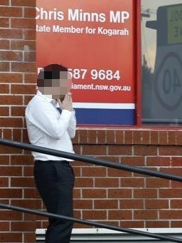 In his electorate of Kogarah a man smokes in front of the Premier’s electorate office.