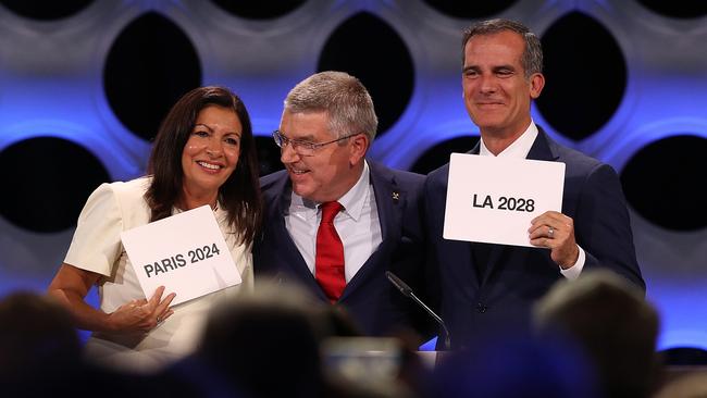 Paris Mayor Anne Hidalgo, IOC President Thomas Bach and Los Angeles Mayor Eric Garcetti react.