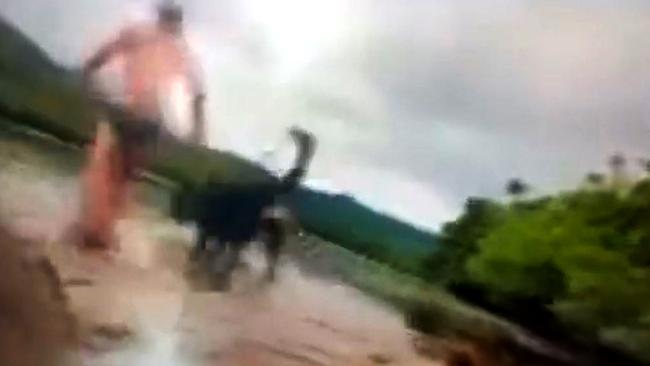 A video still of Alister MacPhee and his dog Molly being attacked by a crocodile near the Bloomfield boat ramp.