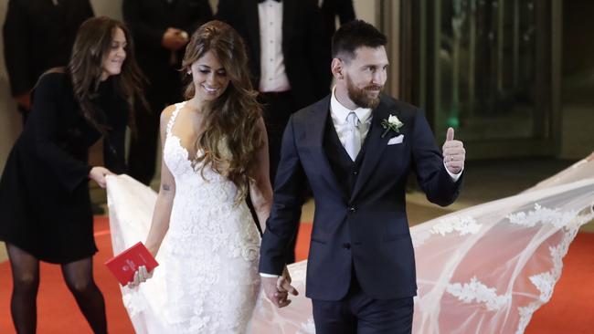 Lionel Messi flashes a thumbs up next to bride Antonella Roccuzzo.