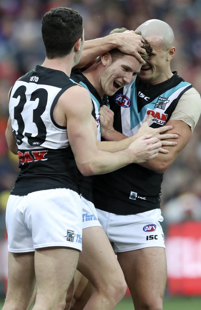 Port Adelaide’s Kane Farrell, centre, celebrates a Showdown goal with Darcy Byrne-Jones, left, and Sam Powell-Pepper. Picture: SARAH REED