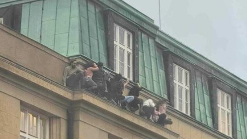 People cling to a ledge to try to escape the gunman. Picture: Supplied