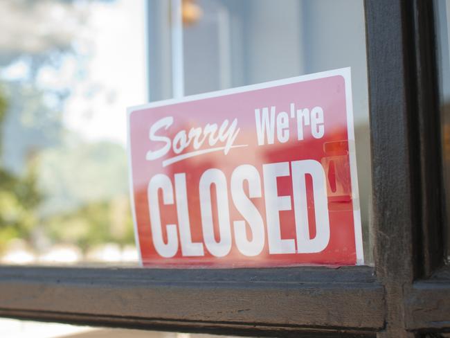 Sorry, We're Closed Sign in a small town main street  storefront window.