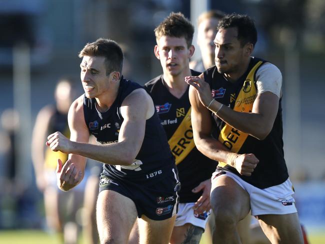 South v Glenelg. Joel Cross just getting a handball away from Marlon Motlop.. It was Marlons 100th game today. MUST CREDIT: CORY SUTTON