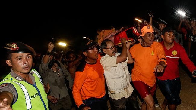 One still missing...An Indonesian rescue team evacuates a Japanese tourist after she was found alive on a reef, in Sanur on February 17 in Denpasar, Bali, Indonesia. Picture: Getty