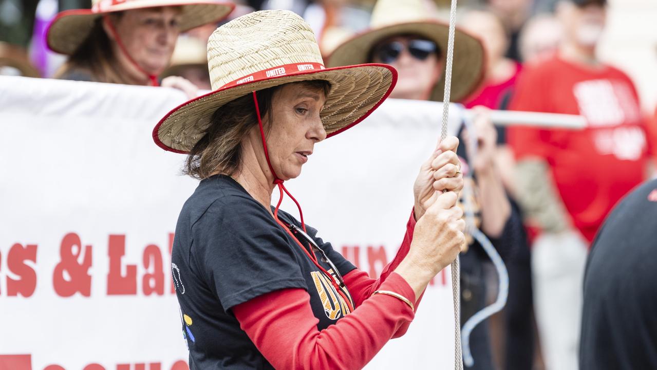 Brenda Heskett holds the flag at half-mast before the Toowoomba Labour Day march, Saturday, April 29, 2023. Picture: Kevin Farmer