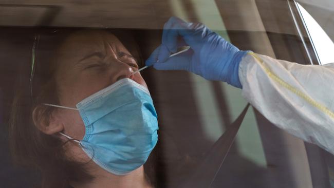 A healthcare worker takes samples from a driver at a drive-through testing point for the COVID-19 disease at the University Hospital in Burgos on April 18.