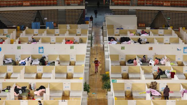 Patients resting at a temporary hospital set up for COVID-19 coronavirus patients in a sports stadium in Wuhan, in China's central Hubei province. Many patients have been discharged after treatment at the temporary hospital, leaving some beds empty. Picture: STR/AFP