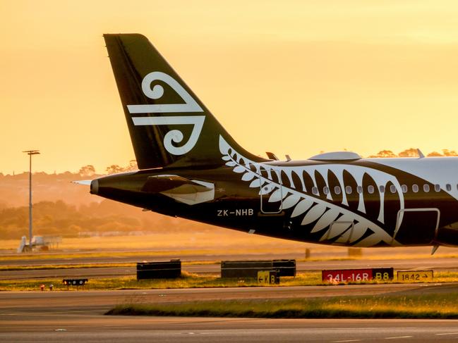 An Air New Zealand Airbus A320-271N plane, registration ZK-NHB, arriving from Queenstown as flight ZK-NHB and taxiing to the international terminal of Sydney Kingsford-Smith Airport.   She is passing information signs about the main runway (red and white) and taxiways (yellow and black).  This image was taken from Shep's Mound, Mascot at sunset on 25 August 2023.Escape 28 April 2024Doc HolidayPhoto : iStock