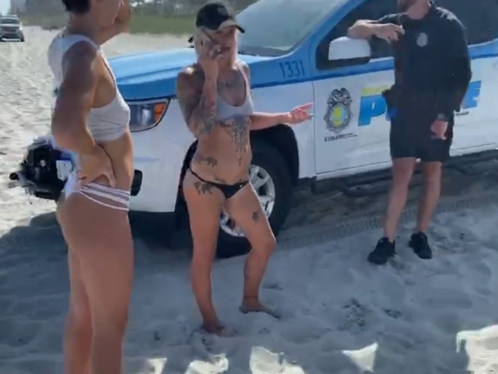 Woman handcuffed for wearing G string bikini on beach Photo