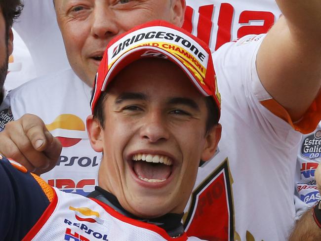 Spain's Marc Marquez celebrates with team members after winning this year's championship at the Japanese Motorcycle Grand Prix at Twin Ring Motegi circuit in Motegi, north of Tokyo, Japan, Sunday, Oct. 12, 2014. Honda rider Marquez defended his MotoGP championship on Sunday when he finished second in the Grand Prix of Japan behind compatriot Jorge Lorenzo.(AP Photo/Shizuo Kambayashi)