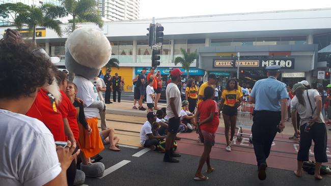 Stolenwealth Games protesters sit on tramlines blocking off Scarborough Street, Southport. Picture: Brianna Morris-Grant