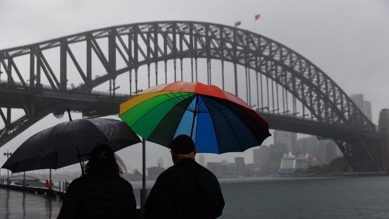 Braving the weather at the Sydney Harbour Bridge. Picture: David Swift