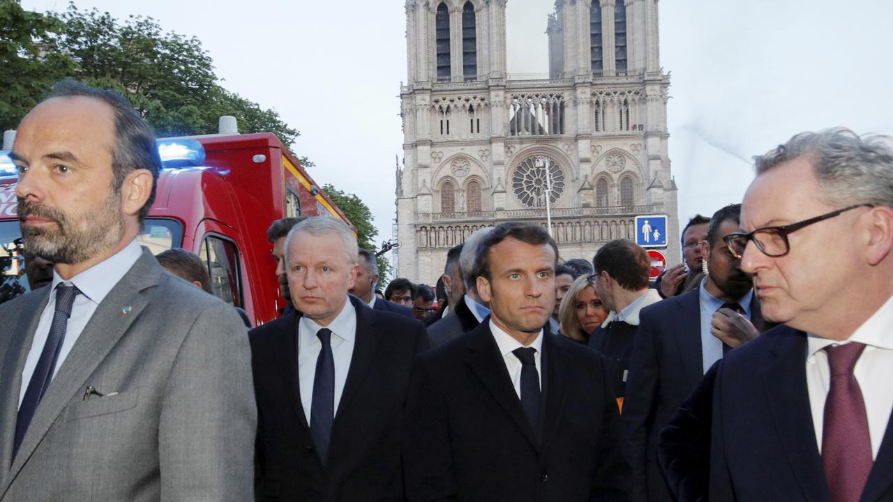 French Prime Minister Edouard Philippe, left, and French President Emmanuel Macron arrive at the cathedral on Monday. Picture: Philippe Wojazer