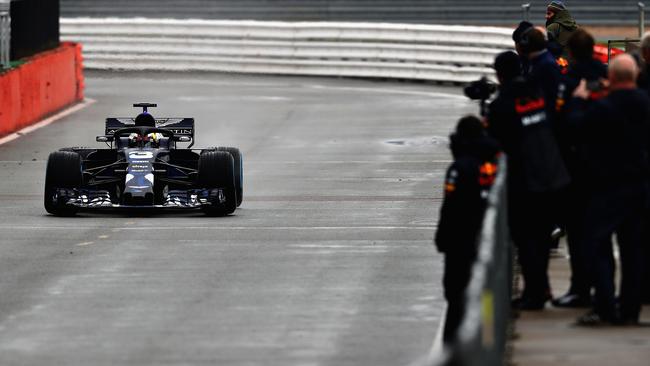 Daniel Ricciardo drives the RB14 as Red Bull crew watch on.