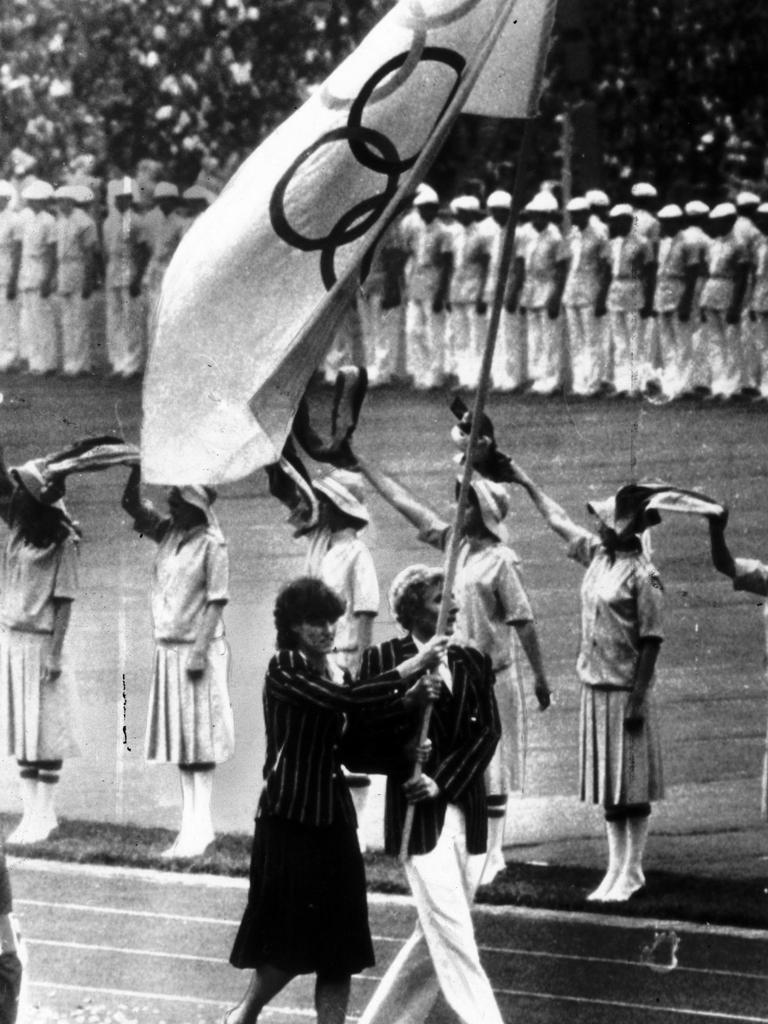 Denise Boyd and Max Metzker lead the team into the Moscow Olympics under the Olympic flag in 1980.