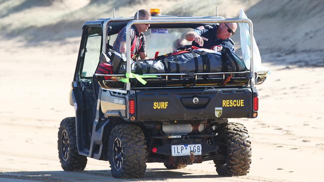 Paramedics take a casualty down the beach to a road ambulance. Picture: Alan Barber