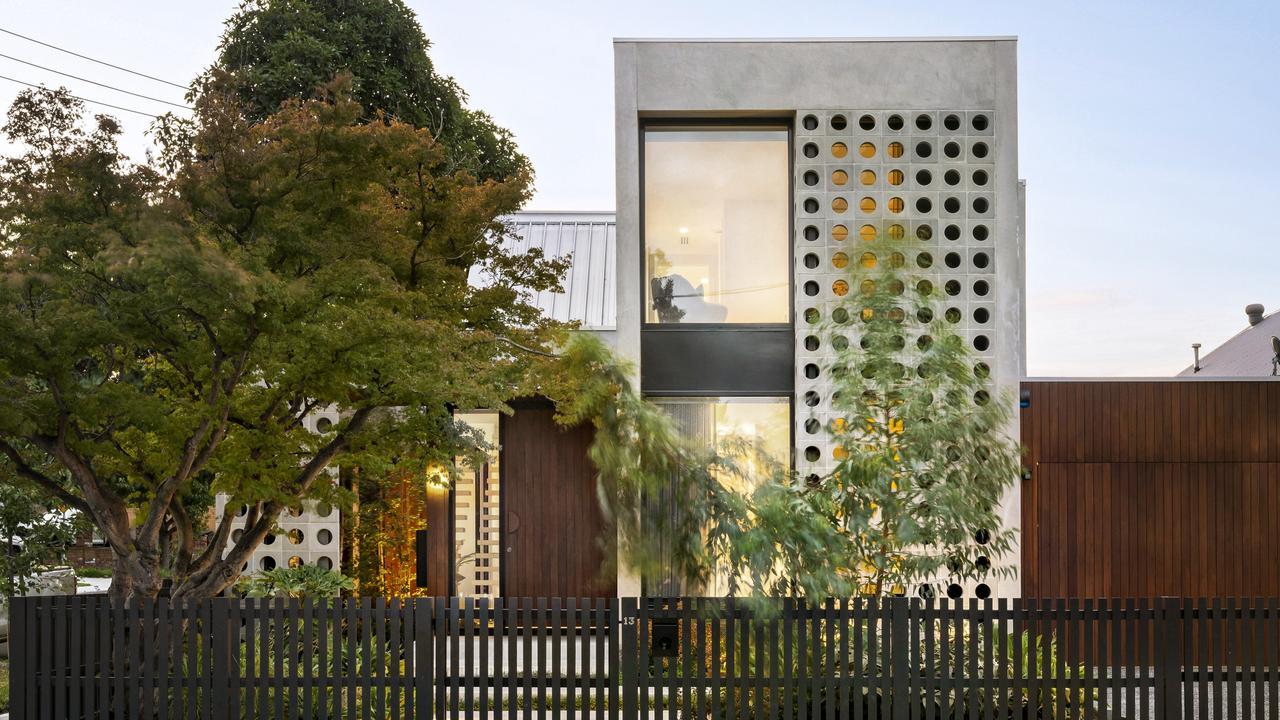 The eye-catching facade and tree-filled front garden at 13 Lyon St, Essendon.